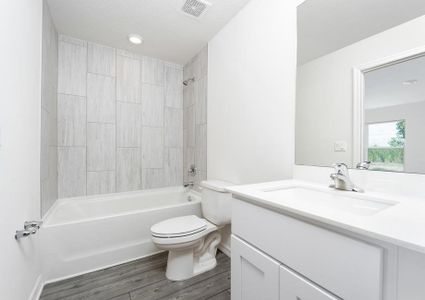 The bathroom has tile detail in the tub/shower combination.