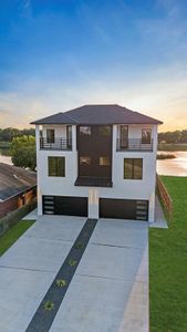 Modern home featuring a lawn, a garage, and a water view