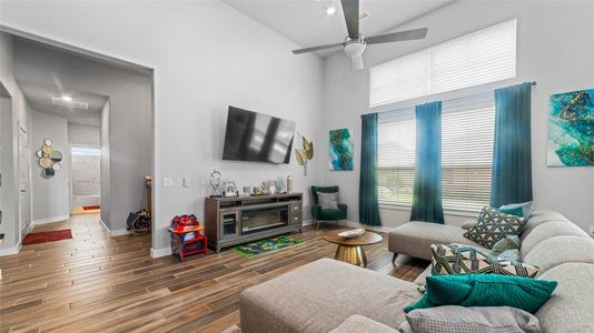 Living room featuring high vaulted ceiling, hardwood / wood-style floors, and ceiling fan