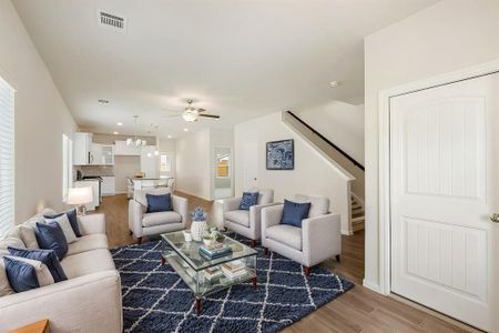 This open-concept living and dining space features vaulted ceilings, wide-format tile flooring, and an abundance of natural light, creating a welcoming area perfect for gatherings and relaxation.