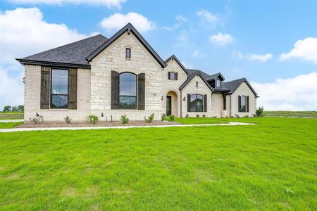 French country inspired facade with a front yard