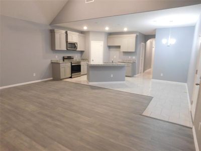 Kitchen featuring light hardwood / wood-style floors, appliances with stainless steel finishes, a kitchen island, and gray cabinetry