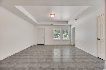 Tiled spare room with a tray ceiling