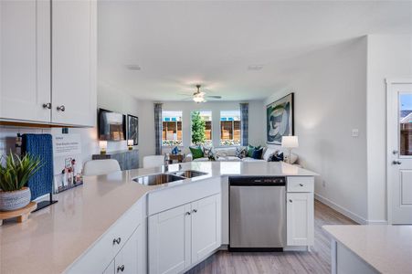 Kitchen featuring light hardwood / wood-style floors, white cabinets, and stainless steel dishwasher