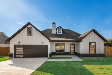 Modern farmhouse style home featuring a front yard and a garage