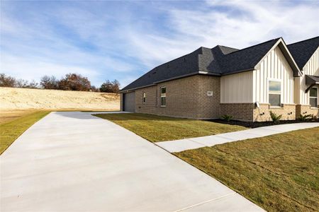 View of home's exterior with a garage and a lawn