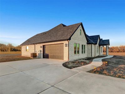 View of side of home featuring a garage and central AC unit