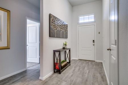 Foyer with baseboards and light wood-style floors