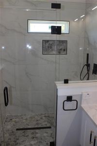 Bathroom with a wealth of natural light, vanity, and an enclosed shower