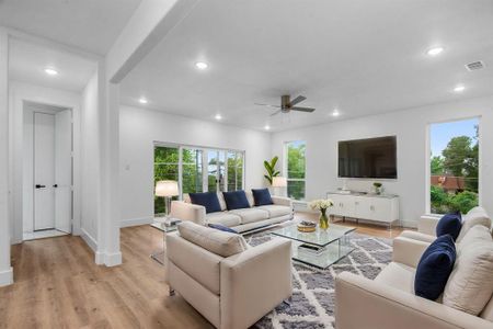 Living room with ceiling fan and light hardwood / wood-style floors