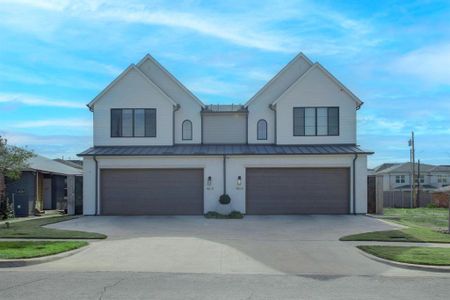 Modern inspired farmhouse with a garage and a front lawn