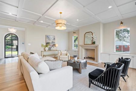 Living room with coffered ceiling and light wood-type flooring