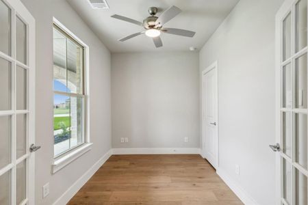 Empty room featuring ceiling fan, french doors, and light hardwood / wood-style floors