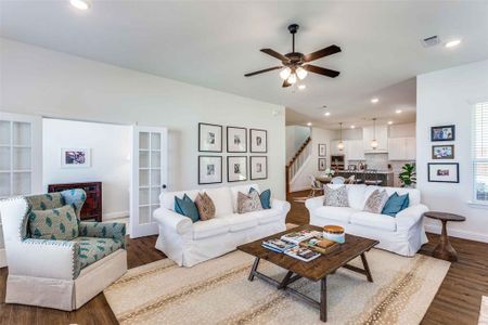 Living room with ceiling fan and hardwood / wood-style flooring