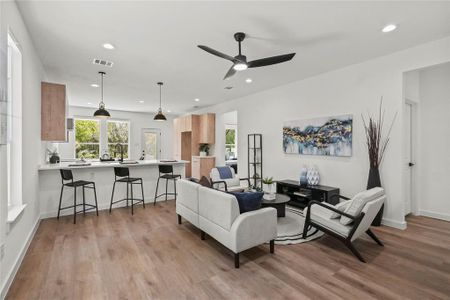 Living room featuring ceiling fan, light wood-type flooring, and sink