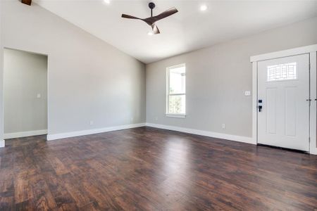 Entryway with a wealth of natural light, dark hardwood / wood-style flooring, vaulted ceiling, and ceiling fan