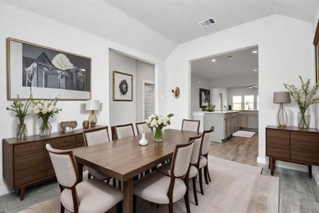 Create lasting memories with your family and friends at the dining table! This expansive dining room showcases sophisticated flooring, custom paint, and seamlessly connects to the family room and kitchen, providing an open and inviting atmosphere. Virtually Staged. Representation photo. Actual colors and selections may vary.