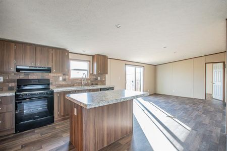 Kitchen with sink, kitchen island, and black appliances