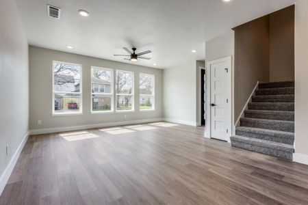 Unfurnished living room with hardwood / wood-style floors, ceiling fan, and a wealth of natural light