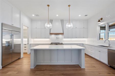 Beautiful chef's kitchen with 48' range and 48" built in fridge and windows overlooking backyard