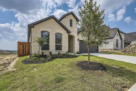 French provincial home with a garage and a front yard