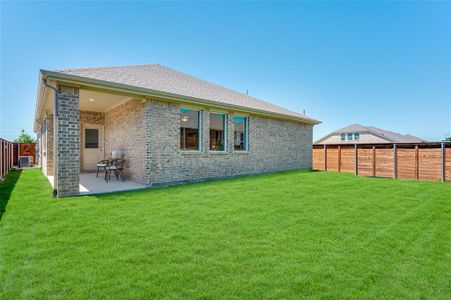 Rear view of house with a lawn, a patio area, and central AC