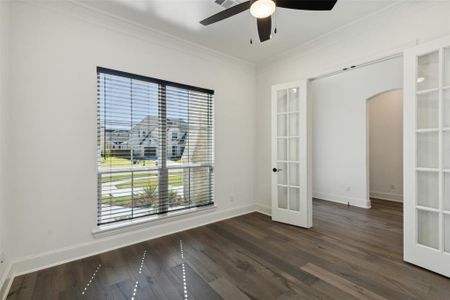 Empty room with french doors, ceiling fan, ornamental molding, and dark hardwood / wood-style flooring