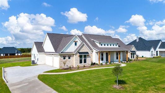 View of front facade featuring cooling unit, a garage, and a front lawn