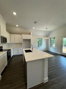 Kitchen featuring sink, a kitchen island with sink, a healthy amount of sunlight, and black appliances