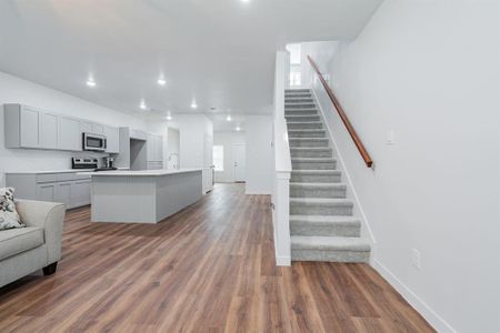 Kitchen featuring appliances with stainless steel finishes, an island with sink, sink, gray cabinetry, and dark hardwood / wood-style flooring