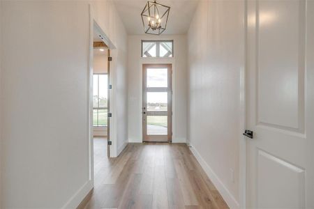 Bright foyer with deco lighting, 3 Light front door and coat closet.