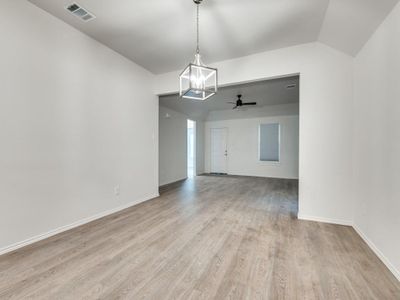 Unfurnished room featuring light hardwood / wood-style floors and ceiling fan with notable chandelier