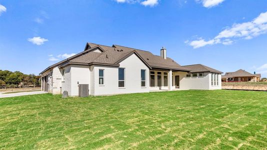 Back of property with central air condition unit and a yard