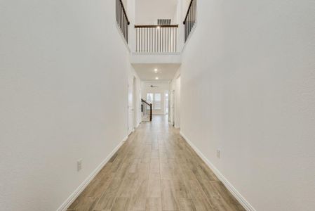 Corridor featuring light wood-type flooring and a high ceiling