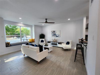 Living room with ceiling fan and hardwood / wood-style flooring