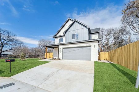 View of front of property with a garage and a virtually colored front yard