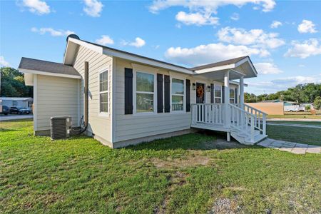 View of front of property featuring a front yard, central air condition unit, and a porch