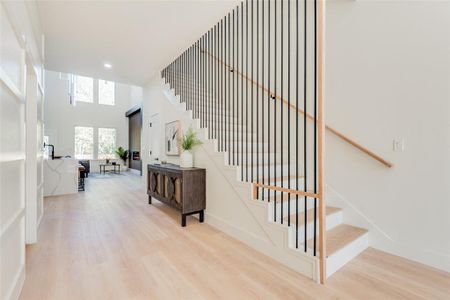 Staircase with hardwood / wood-style flooring and a towering ceiling