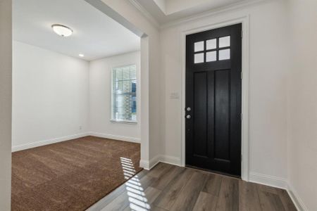 Foyer with dark hardwood / wood-style flooring and crown molding