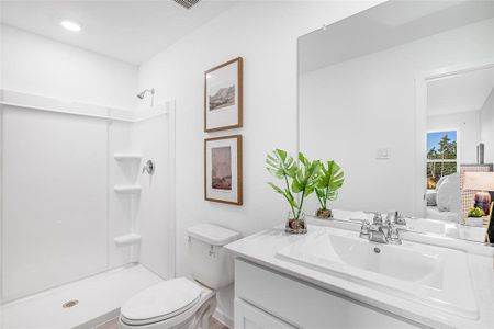 Bathroom with walk in shower, vanity, and toilet