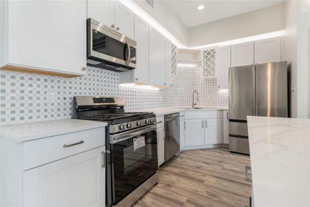 This kitchen will feature white shaker cabinets. Cabinets, appliances, and countertops.