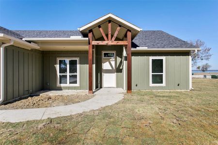 View of exterior entry featuring a yard