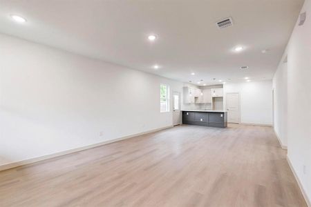 Unfurnished living room featuring light hardwood / wood-style flooring and sink