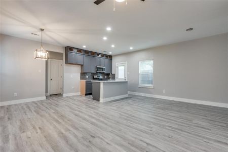 The modern kitchen is a chef's dream featuring stainless steel appliances, an island with a kitchen sink and ample storage space.