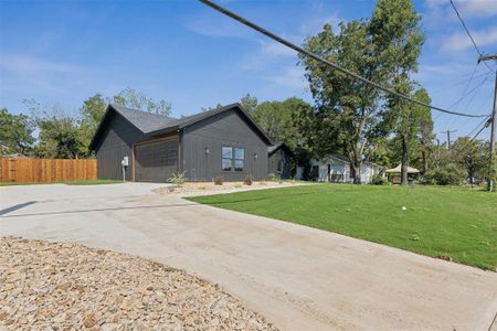 View of side of property with a garage and a lawn