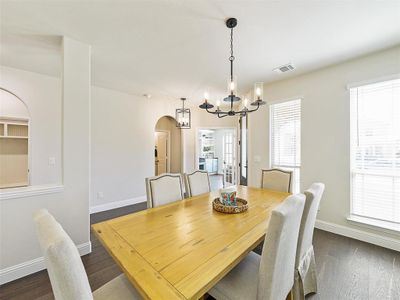 Dining room with a notable chandelier and dark hardwood / wood-style floors