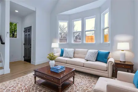 Living area with stairs, baseboards, a wealth of natural light, and light wood-style floors