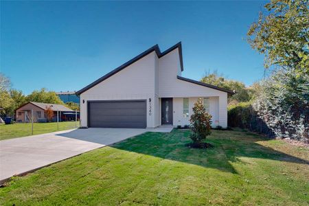 View of front of property featuring a front yard and a garage