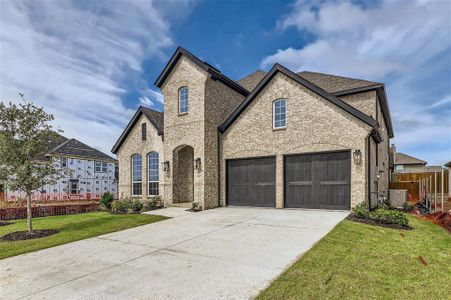 French country inspired facade with central AC, a front lawn, and a garage