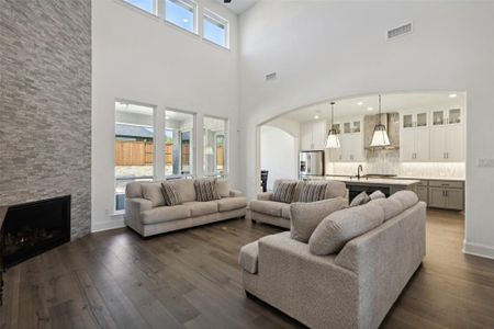 Living room with sink, a fireplace, a high ceiling, and dark hardwood / wood-style floors